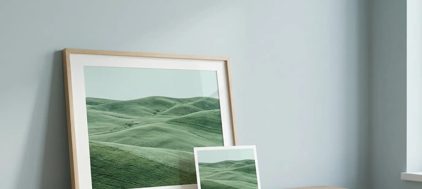 A large framed photograph beside a small neat print of the same image on a light desk